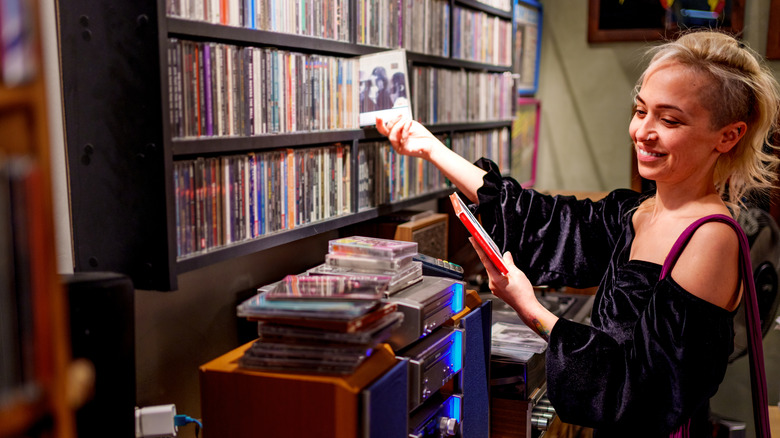 A young woman looking through physical media at a store