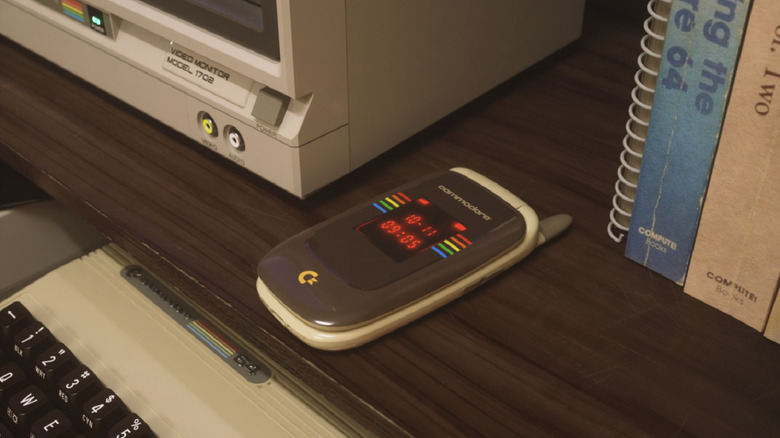 The Commodore Callback Beige Edition sitting on a desk surrounded by retro parephenalia