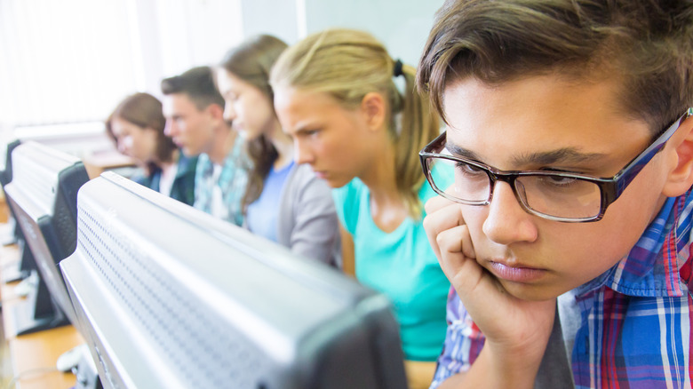 bored students starting at computer screens in school