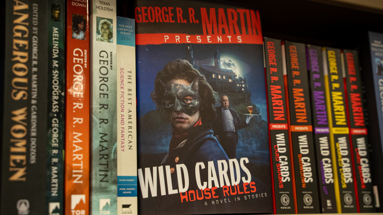 "Wild Cards" books on a bookshelf.