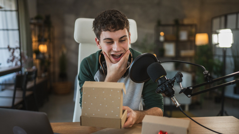 Joyful person opening gifts at a desk