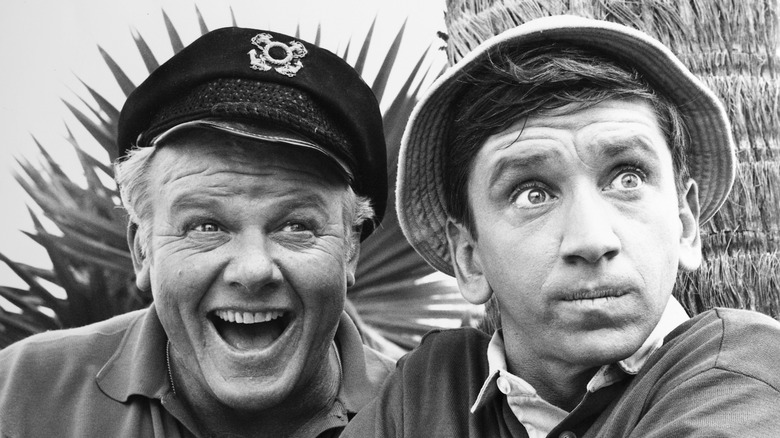 Black and white image of Skipper and Gilligan smiling while looking at the camera