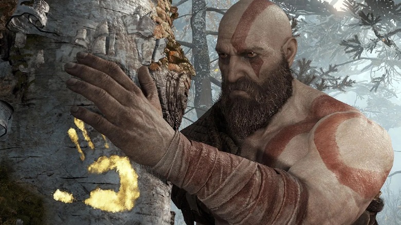 Kratos touching the tree with his wife's handprint on from God of War 2018