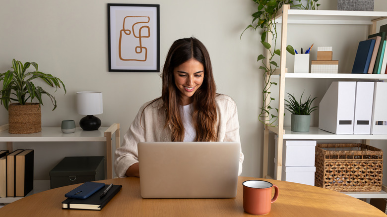 A smiling woman working in her home office.