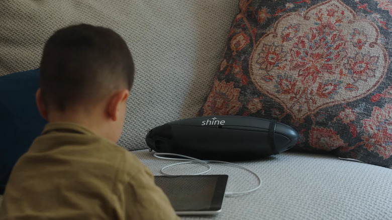Child using Shine 2.0 as power bank to charge iPad device