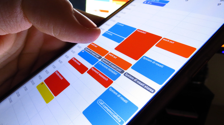 Close-up of a person holding a smartphone with Google Calendar on the screen