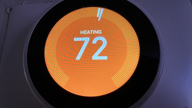 Google Nest thermostat on the wall showing current indoor temperature.