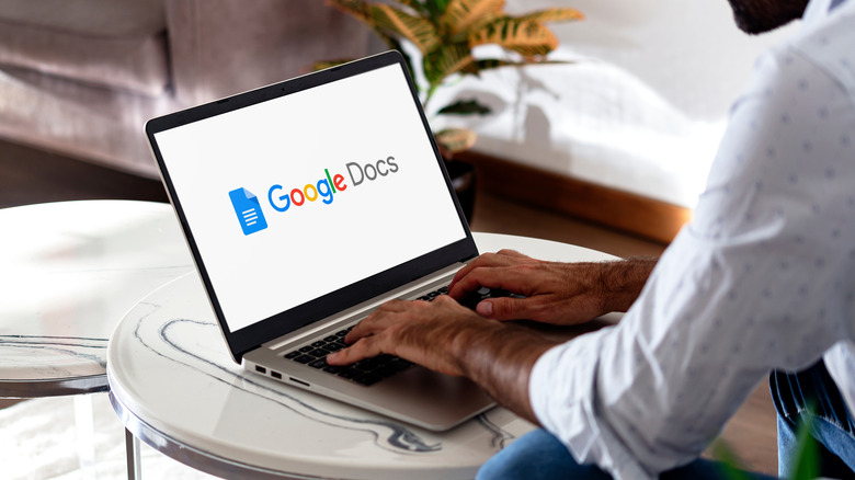 man using Google Docs on a laptop, Google Docs logo showing on white screen on laptop mockup
