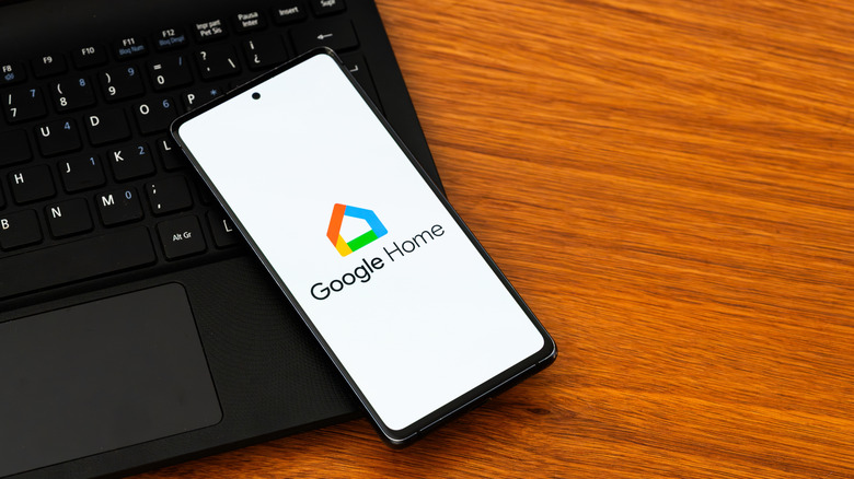 The Google Home logo displayed on a phone that's lying on top of a laptop