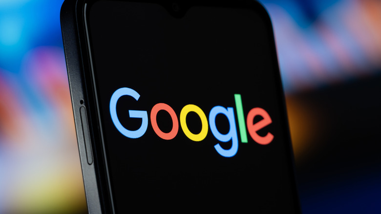 A smartphone displaying the Google logo, the background to the image is highly blurred
