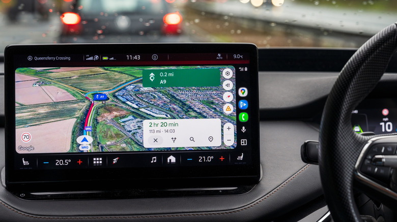 Car interior with phone displaying Google Maps