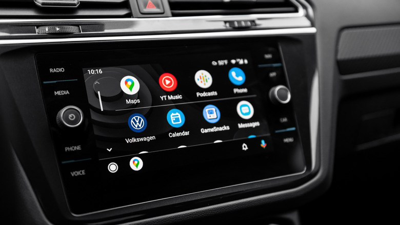 A closeup of an infotainment screen within a vehicle's dashboard that is displaying several apps from the Android Auto Home screen