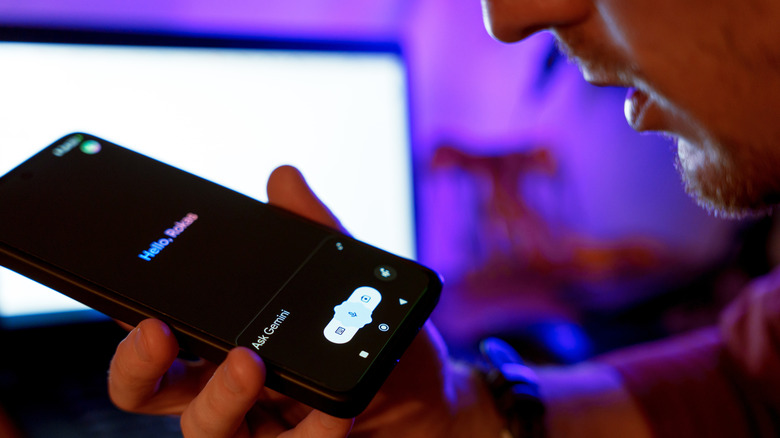 A hand holding a smartphone with Gemini's voice feature on.