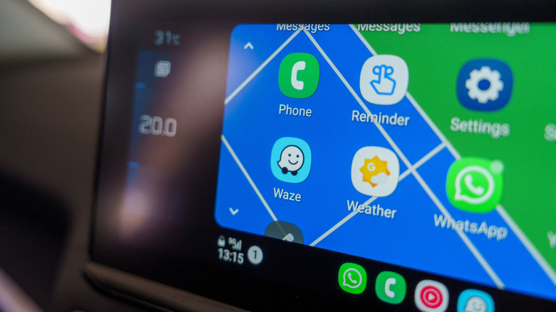 Close-up of a car's infotainment screen displaying Waze and other apps via Android Auto