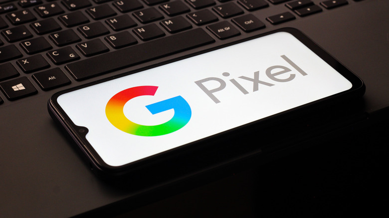 Phone with the Google Pixel logo displayed on it, resting on a laptop