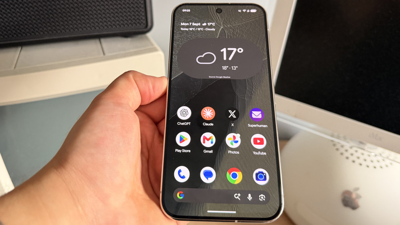Pixel 11 Pro XL Display being held above vintage computers