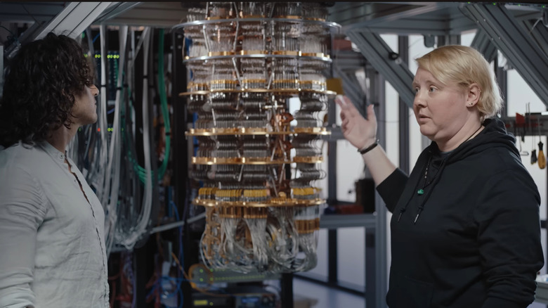 A pair of quantum hardware engineers show off Google's dilution refrigerator, a key component of preparing qubits for quantum computing.