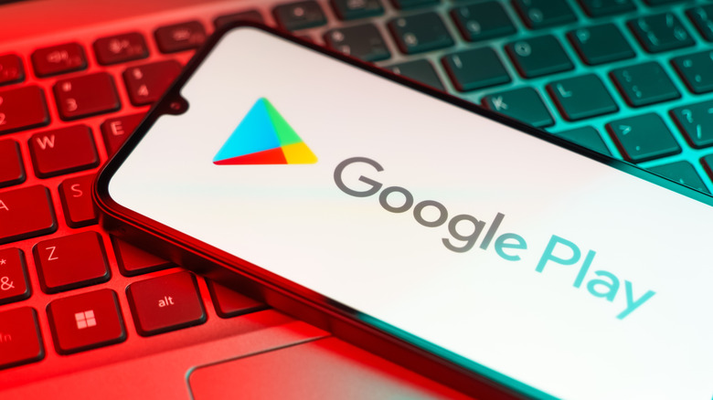 Smartphone displaying Google Play logo on laptop keyboard