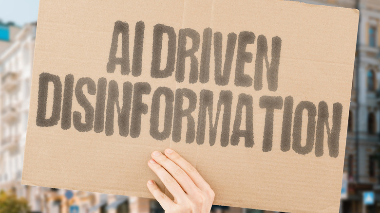 A hand holding up a sign that says "AI Driven Disinformation."