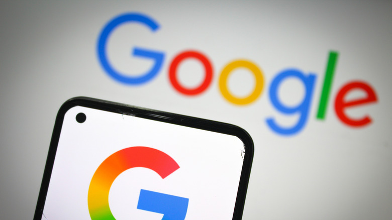 Google logo on smartphone with Google written on white background