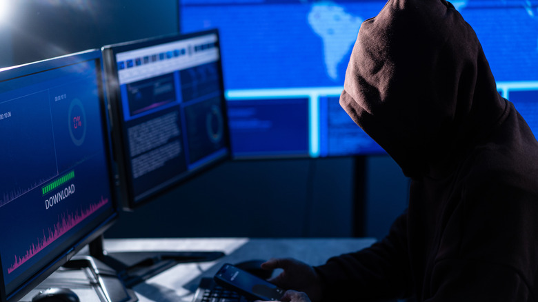 Hacker in front of computer engaging in a phishing attack