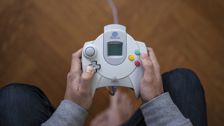 Person holding Sega Dreamcast controller