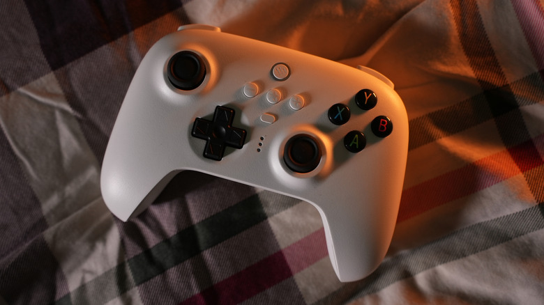 White 8BitDo wireless controller resting on plaid fabric surface