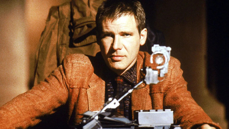 Rick Deckard conducting an interrogation while sitting at a table