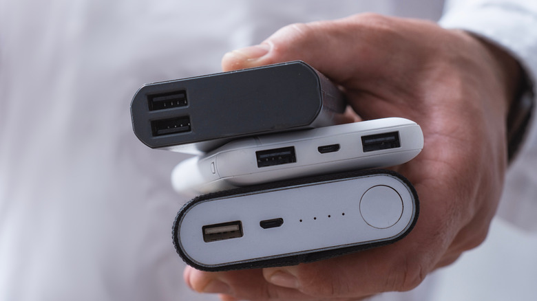 A person holding three different power banks