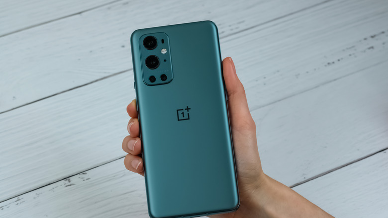 hand holding oneplus smartphone with back facing the camera