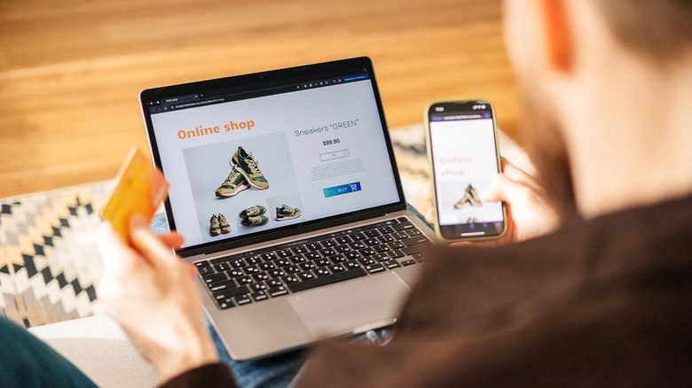Man shopping for shoes online with laptop and smartphone