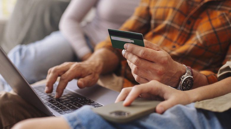 People shopping online while using a laptop and credit card