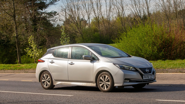 a silver 2021 Nissan Leaf driving on the road