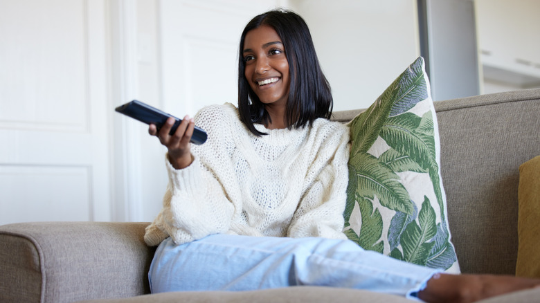 a woman watching TV on her couch