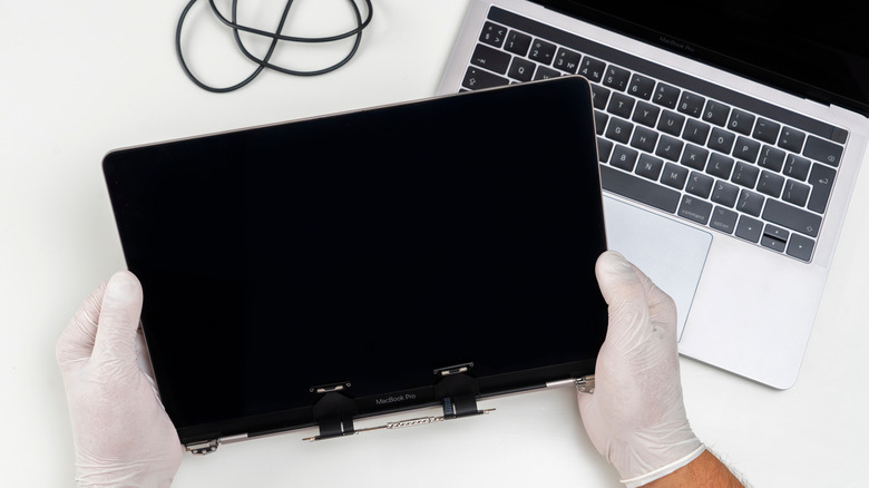 A person replacing a MacBook Pro's display.