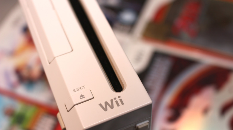Close up of a Nintendo Wii console on top of blurred game boxes