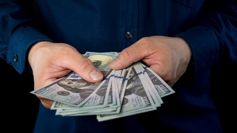 Man holding hundred-dollar bills