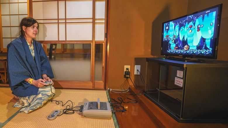 woman playing SNES on a TV