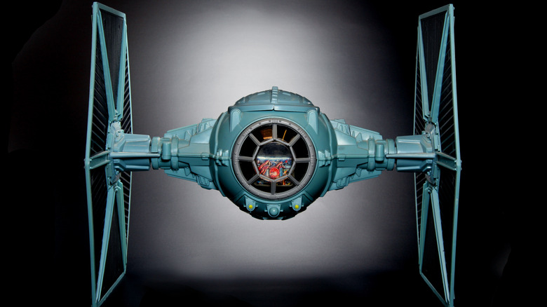 A closeup model of a tie fighter against a black background