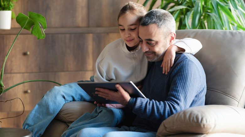 Father and daughter using a tablet together.
