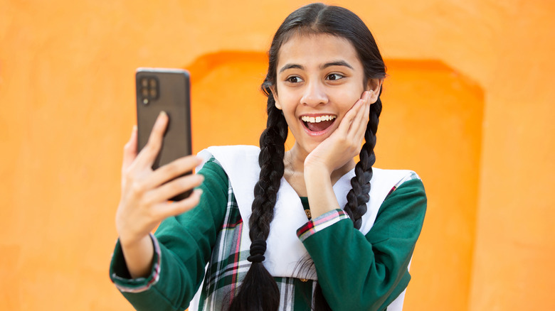 Young girl using a smartphone and smiling.