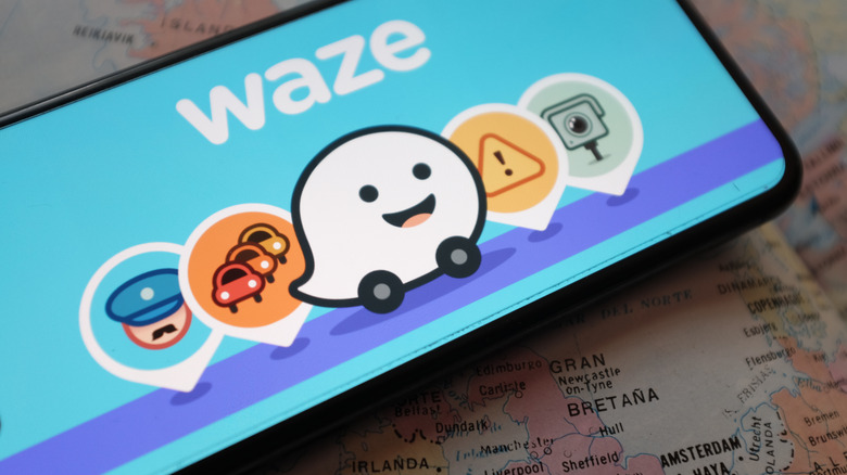Close up of Waze icons and warning indicator on a smartphone display.