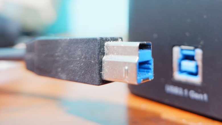 A USB cable featuring Type-B connector being connected to a Type-B port