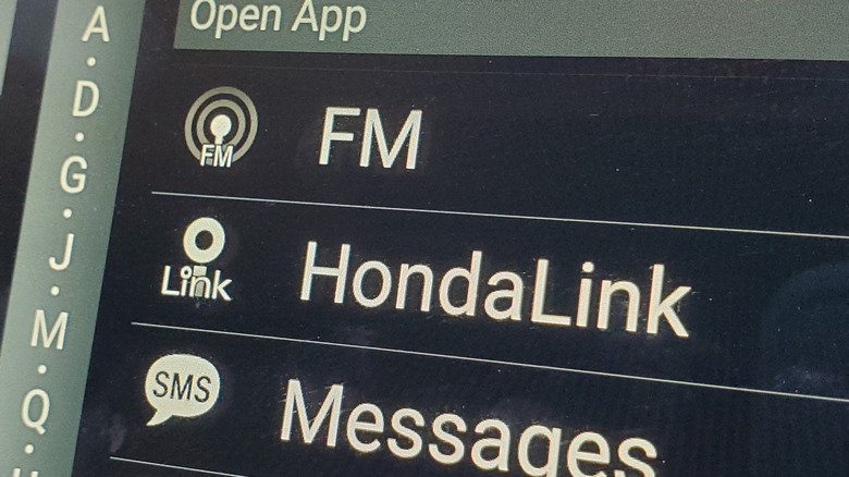 close-up of dashboard infotainment system showing HondaLink option in list with FM radio and Messages options.