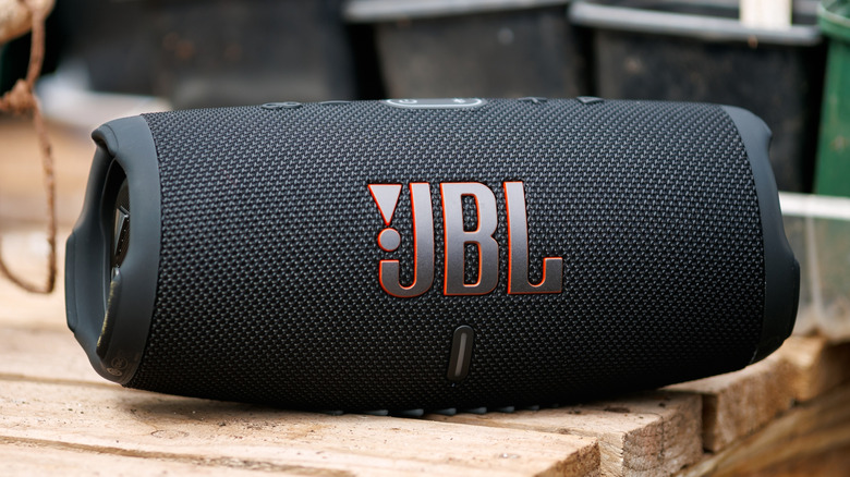 JBL portable Bluetooth speaker on wooden table outdoors