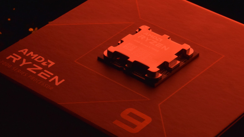 An AMD Ryzen 9 7000 CPU lying on top of its box with red lighting