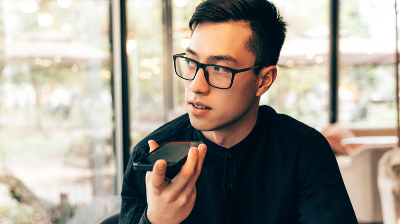 A man using the speakerphone function to talk.