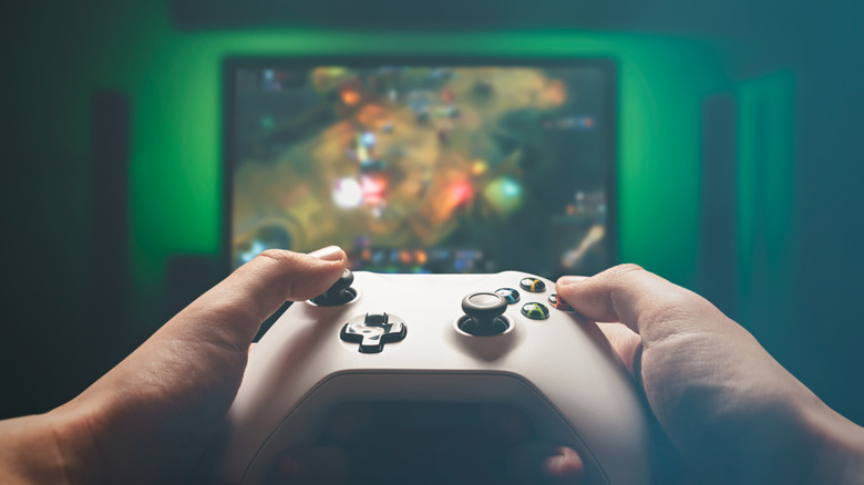 Hand using a controller to play a n action RPG on an Xbox