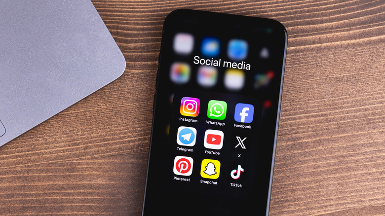 Phone with social media icon apps on a screen Facebook, Instagram, WhatsApp, Telegram, and more