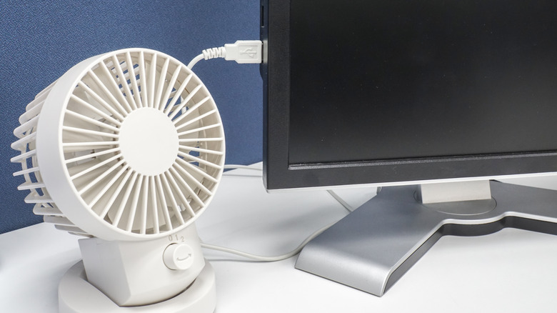 White portable USB fan connected to a computer monitor